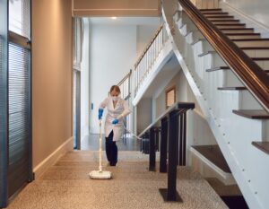 photo avec une femme de menage qui fait du ménage dans un syndic de copropriétés ou il y a des escaliers et des cages d'escaliers